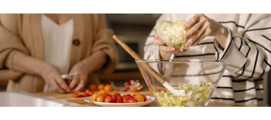 Two women preparing healthy organic food to help lower cancer risk