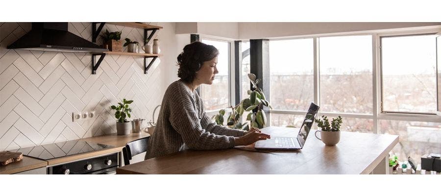 Woman researching sustainable home tips at her kitchen table