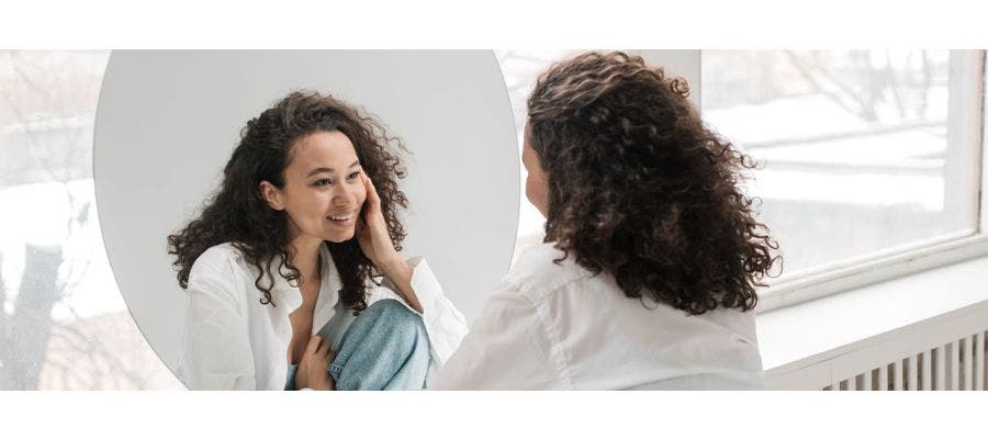 Woman smiling at herself in the mirror
