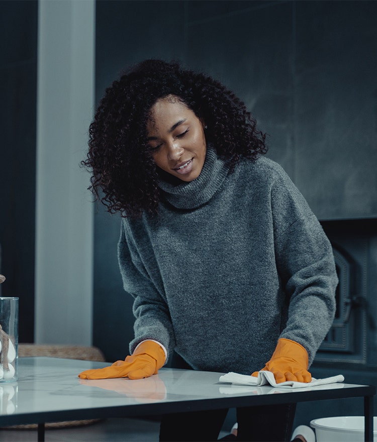 Woman cleaning the kitchen countertop with a reusable cloth towel