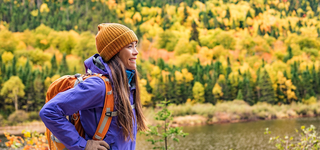 backpacker looking at autumn leaves