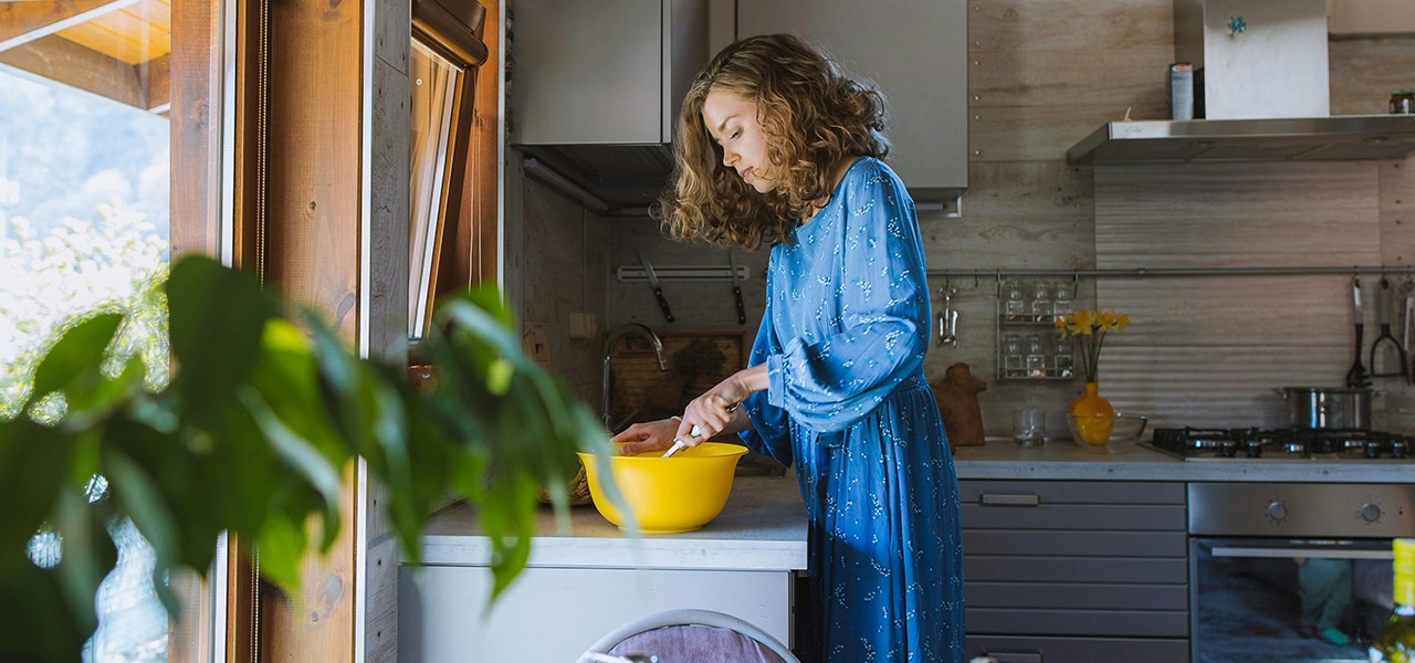 woman in kitchen mixing food in a bowl
