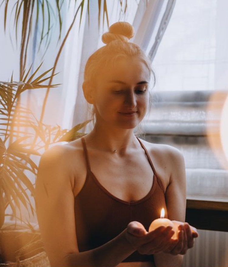 Woman holding a candle and meditating