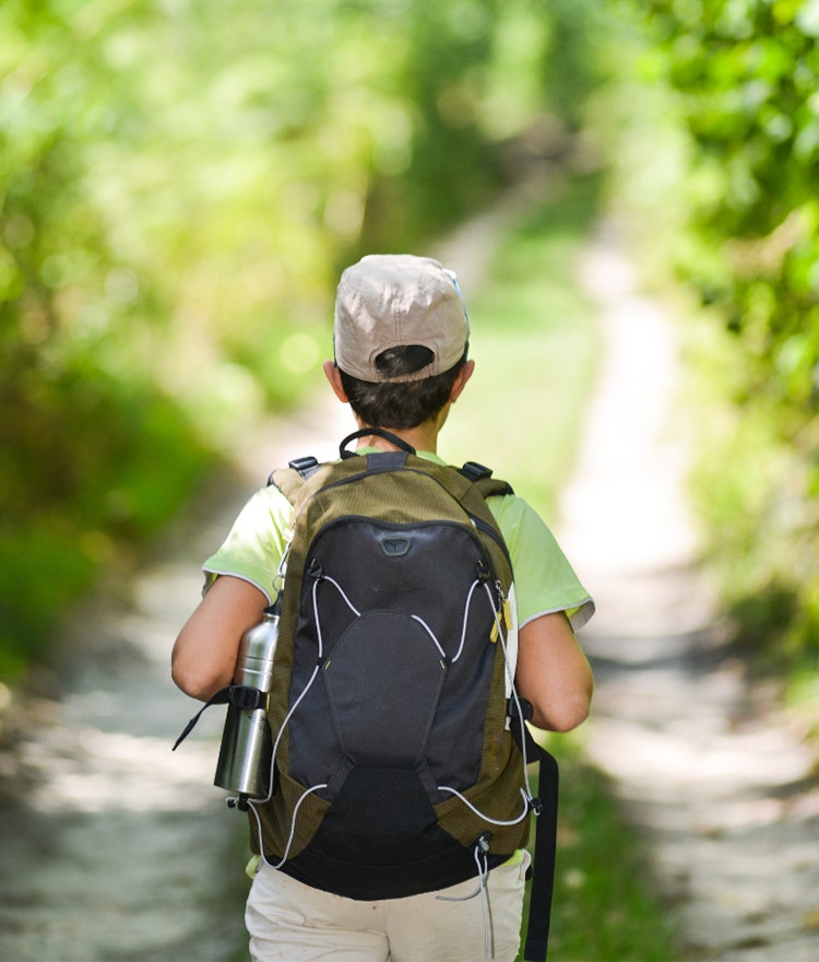 Person hiking in the woods as self care