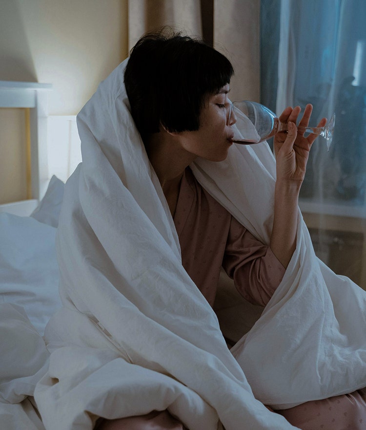 woman drinking sleepy girl mocktail in bed