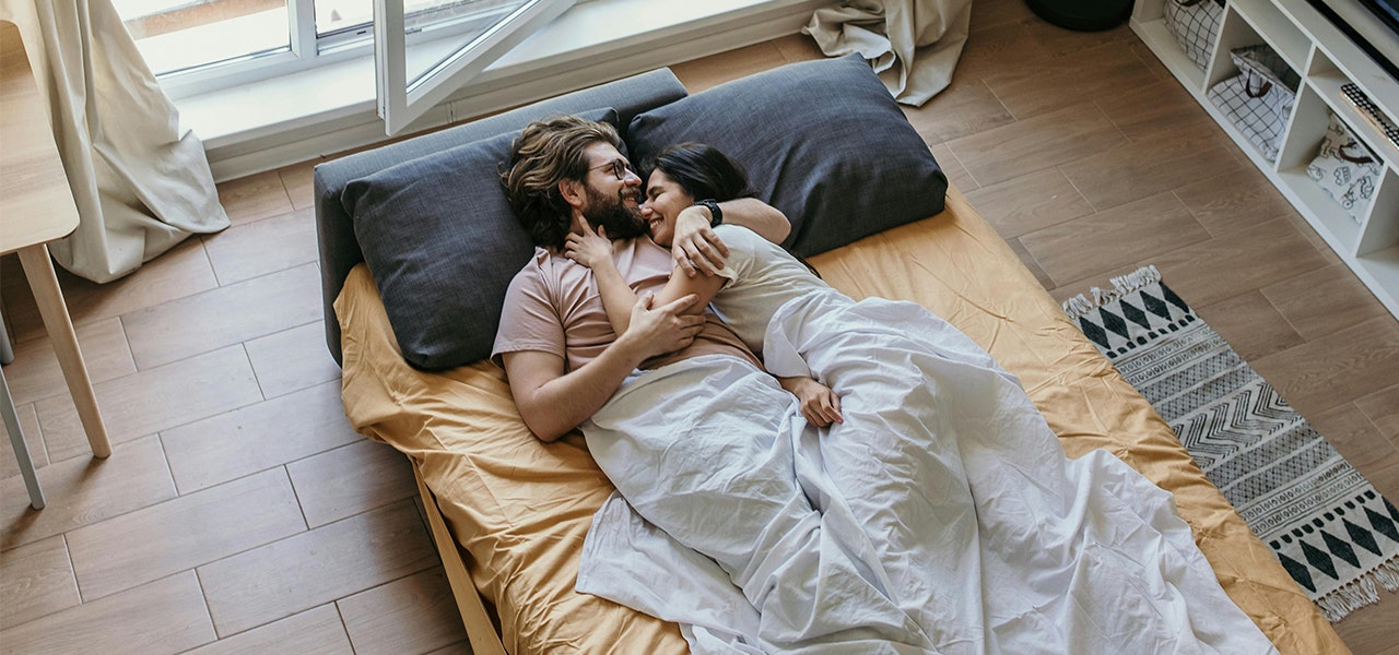 couple snuggling in bed and smiling