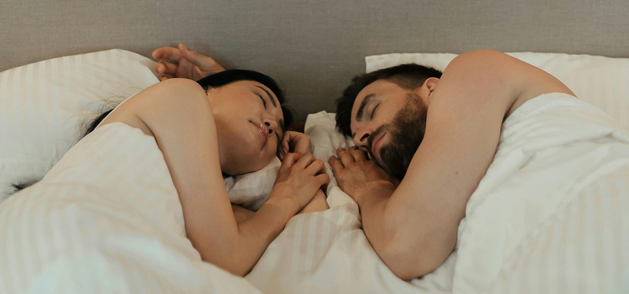 couple sleeping face to face in bed