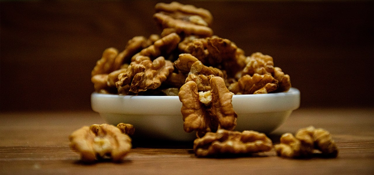 white bowl overflowing with walnut halves