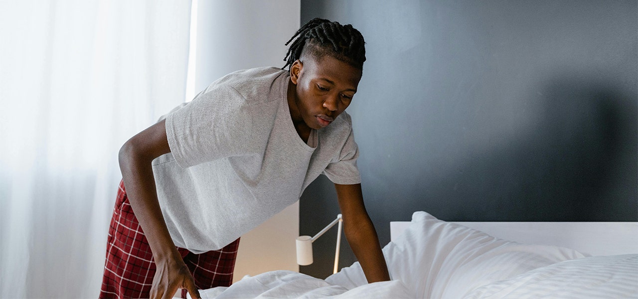 adult male making his bed